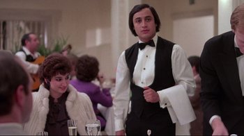 Movie still from “El Norte” (1983), directed by Gregory Nava – A man standing next to a woman at a table; Medium shot, Low angle