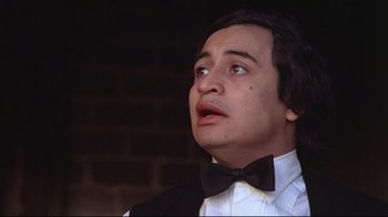 Movie still from “El Norte” (1983), directed by Gregory Nava – A person wearing a suit and bow tie; Close Up shot, Low angle
