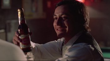 Movie still from “El Norte” (1983), directed by Gregory Nava – A man holding a bottle of beer in his right hand; Close Up shot, Low angle