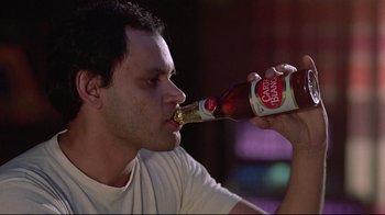 Movie still from “El Norte” (1983), directed by Gregory Nava – A young man drinking a beer from a bottle; Close Up shot, Low angle