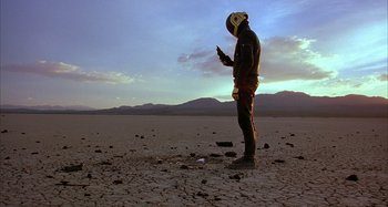 A man standing in the middle of an empty field