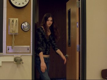 A woman is walking through a door way