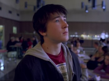 Movie still from “Elephant” (2003), directed by Gus Van Sant – A young man looking up into the air; Close Up shot, Over the shoulder angle