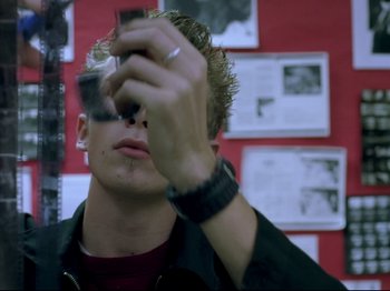 Movie still from “Elephant” (2003), directed by Gus Van Sant – A man taking a picture with a cell phone; Close Up shot, Low angle