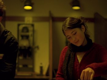 Movie still from “Elephant” (2003), directed by Gus Van Sant – A young woman wearing a red sweater and a black scarf; Medium shot, Low angle