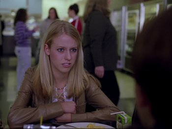 Movie still from “Elephant” (2003), directed by Gus Van Sant – A woman sitting in front of a plate of food in a restaurant; Close Up shot, Over the shoulder angle