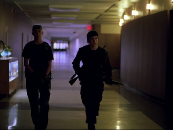 Movie still from “Elephant” (2003), directed by Gus Van Sant – Two men walking down a hallway holding guns; Medium shot, Low angle