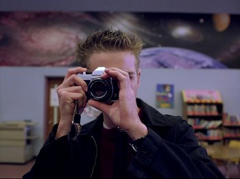 Movie still from “Elephant” (2003), directed by Gus Van Sant – A man taking a picture of himself in a mirror; Close Up shot, Low angle