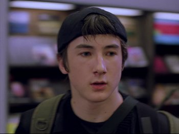 Movie still from “Elephant” (2003), directed by Gus Van Sant – A young man wearing a hat and a backpack; Close Up shot, Over the shoulder angle