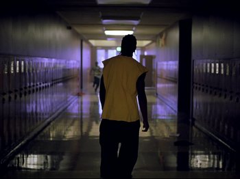 Movie still from “Elephant” (2003), directed by Gus Van Sant – A man walking down a hallway in a school; Wide shot, Low angle