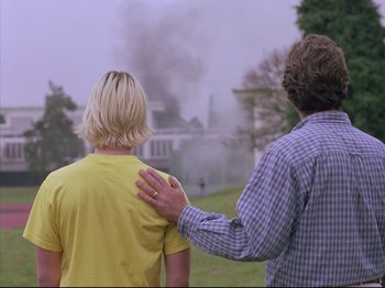 Movie still from “Elephant” (2003), directed by Gus Van Sant – Two people standing next to each other in front of a fire; Medium shot, Over the shoulder angle