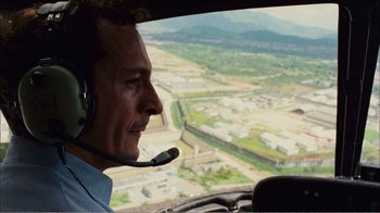 Movie still from “Elite Squad 2: The Enemy Within” (2010), directed by José Padilha – A man in a helicopter looking out over a city; Close Up shot, High angle