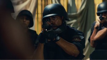 Movie still from “Elite Squad 2: The Enemy Within” (2010), directed by José Padilha – A man in a police uniform is holding a gun; Close Up shot, Over the shoulder angle