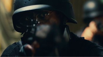 Movie still from “Elite Squad 2: The Enemy Within” (2010), directed by José Padilha – A man wearing a helmet is holding a gun; Close Up shot, Over the shoulder angle