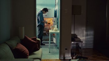 Movie still from “Elite Squad 2: The Enemy Within” (2010), directed by José Padilha – A man standing in front of an open refrigerator; Wide shot, High angle