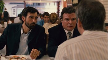 Movie still from “Elite Squad 2: The Enemy Within” (2010), directed by José Padilha – A couple of men sitting at a table with food in front of them; Medium shot, Over the shoulder angle