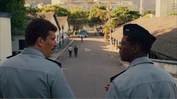 Movie still from “Elite Squad 2: The Enemy Within” (2010), directed by José Padilha – Two police officers standing on the side of the street; Medium shot, Over the shoulder angle
