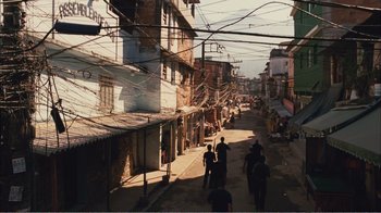 Movie still from “Elite Squad 2: The Enemy Within” (2010), directed by José Padilha – A group of people walking down a street near buildings; Extreme Wide shot, High angle