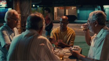 Movie still from “Elite Squad 2: The Enemy Within” (2010), directed by José Padilha – A group of people sitting at a table playing a card game; Medium shot, Over the shoulder angle