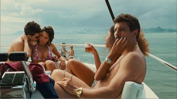 Movie still from “Elite Squad 2: The Enemy Within” (2010), directed by José Padilha – A group of people sitting on top of a boat; Medium shot, Over the shoulder angle