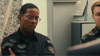 Movie still from “Elite Squad 2: The Enemy Within” (2010), directed by José Padilha – A man in a police uniform sitting in front of a wall; Close Up shot, Over the shoulder angle