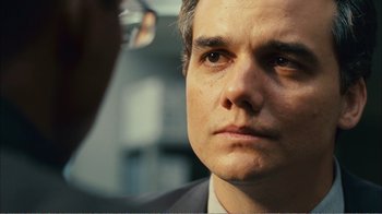 Movie still from “Elite Squad 2: The Enemy Within” (2010), directed by José Padilha – A person wearing a suit and tie; Close Up shot, Over the shoulder angle