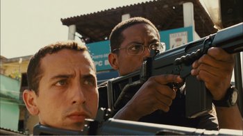 Movie still from “Elite Squad 2: The Enemy Within” (2010), directed by José Padilha – Two men are holding guns in their hands; Close Up shot, Low angle