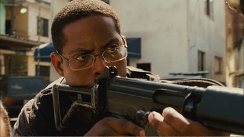 Movie still from “Elite Squad 2: The Enemy Within” (2010), directed by José Padilha – A man with glasses is holding a rifle; Close Up shot, High angle