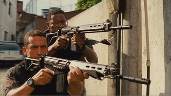 Movie still from “Elite Squad 2: The Enemy Within” (2010), directed by José Padilha – Two men are holding guns in their hands; Medium shot, Low angle