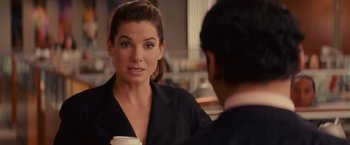 Movie still from “The Proposal” (2009), directed by Anne Fletcher – A woman holding a cup of coffee and talking to a man; Close Up shot, Over the shoulder angle