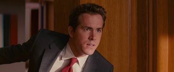 Movie still from “The Proposal” (2009), directed by Anne Fletcher – A person wearing a suit and tie; Close Up shot, Over the shoulder angle