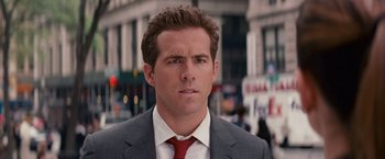 Movie still from “The Proposal” (2009), directed by Anne Fletcher – A person wearing a suit and tie; Close Up shot, Over the shoulder angle