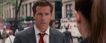 Movie still from “The Proposal” (2009), directed by Anne Fletcher – A person wearing a suit and tie; Close Up shot, Over the shoulder angle