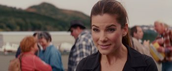 Movie still from “The Proposal” (2009), directed by Anne Fletcher – A person smiling at the camera; Close Up shot, Over the shoulder angle