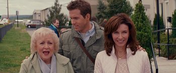 Movie still from “The Proposal” (2009), directed by Anne Fletcher – A man and two women standing next to each other; Medium shot, Over the shoulder angle