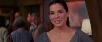 Movie still from “The Proposal” (2009), directed by Anne Fletcher – A person smiling for the camera; Close Up shot, Over the shoulder angle