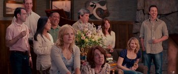 Movie still from “The Proposal” (2009), directed by Anne Fletcher – A group of people sitting in a living room together; Medium shot, Over the shoulder angle