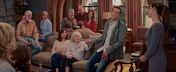 Movie still from “The Proposal” (2009), directed by Anne Fletcher – A group of people sitting around a living room; Medium shot, Over the shoulder angle