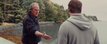Movie still from “The Proposal” (2009), directed by Anne Fletcher – A man standing next to another man near a body of water; Medium shot, Over the shoulder angle