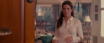 Movie still from “The Proposal” (2009), directed by Anne Fletcher – A woman in a white shirt holding a bowl in a kitchen; Medium shot, Over the shoulder angle