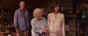 Movie still from “The Proposal” (2009), directed by Anne Fletcher – Two women standing next to each other in front of a stone wall; Medium shot, Over the shoulder angle