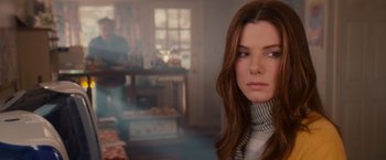 Movie still from “The Proposal” (2009), directed by Anne Fletcher – A beautiful woman with long brown hair wearing a scarf; Close Up shot, Over the shoulder angle