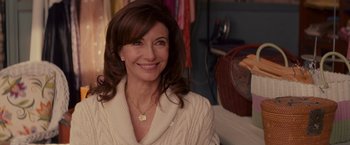 Movie still from “The Proposal” (2009), directed by Anne Fletcher – A woman in a white sweater smiling for the camera; Close Up shot, Over the shoulder angle