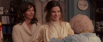 Movie still from “The Proposal” (2009), directed by Anne Fletcher – A woman in a white dress smiling for the camera; Medium shot, Over the shoulder angle