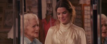 Movie still from “The Proposal” (2009), directed by Anne Fletcher – A woman and an older woman standing next to each other in front of mannequins; Close Up shot, Over the shoulder angle