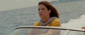 Movie still from “The Proposal” (2009), directed by Anne Fletcher – A woman sitting in the back seat of a boat on the water; Close Up shot, High angle