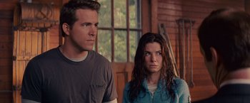 Movie still from “The Proposal” (2009), directed by Anne Fletcher – A man and a woman standing next to each other in front of a window; Close Up shot, Over the shoulder angle
