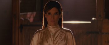 Movie still from “The Proposal” (2009), directed by Anne Fletcher – A woman in a white shirt is standing in a room; Close Up shot, Low angle