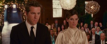 Movie still from “The Proposal” (2009), directed by Anne Fletcher – A man and a woman standing next to each other in front of a group of people; Close Up shot, Low angle