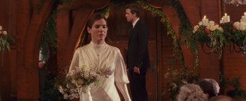 Movie still from “The Proposal” (2009), directed by Anne Fletcher – A man and a woman in wedding attire standing next to each other in front of an archway; Medium shot, Over the shoulder angle